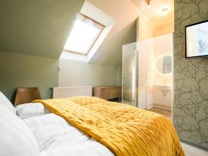 a bedroom with a bed with a yellow blanket on it at Stuckhotel Fettehenne in Ratingen