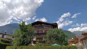 a building with a balcony with mountains in the background at Casa Natalie in Pinzolo