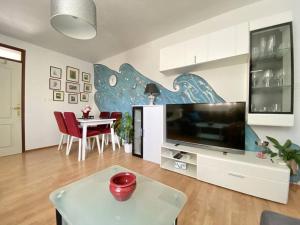 a living room with a large television and a table at Lovely Apartment Marina Blue in Skrbčići