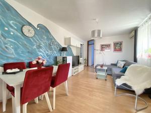a living room with a table and a clock on a wall at Lovely Apartment Marina Blue in Skrbčići