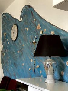 a table with a lamp and a clock on a wall at Lovely Apartment Marina Blue in Skrbčići
