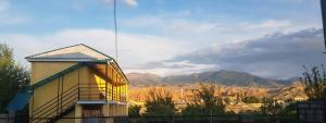 a building with a view of the mountains at " UMAR " Guest house in Tong