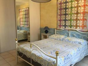 een slaapkamer met een bed en een spiegel bij Villa clochette in Les Arcs sur Argens