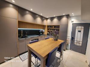 a dining room with a wooden table and blue chairs at Luxury Suite - סוויטת בוטיק in Caesarea