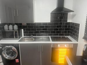 a kitchen with a sink and a stove top oven at Dynasty Lodge in Manchester