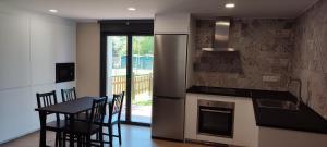 a kitchen with a table and chairs and a refrigerator at Alojamientos Rurales Collera in Ribadesella