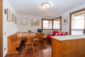 a kitchen and living room with a table and chairs at Condominio Le Marmotte in Selva di Cadore