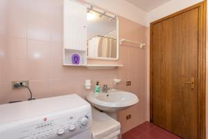 a bathroom with a sink and a toilet and a mirror at Condominio Le Marmotte in Selva di Cadore +35 photos