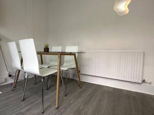a dining room with a table and white chairs at Spectacular 2 bedroom on Tower Bridge in London +3 photos