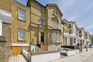 uma fila de casas de tijolos numa rua em Beautiful Battersea Home by Clapham Junction by UnderTheDoormat em Londres