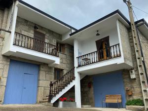 Edificio con 2 puertas azules y balcón en Casa Prada en Sanabria, en Sotillo de Sanabria