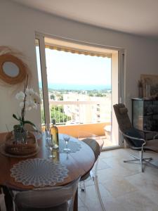 a dining room with a table and a large window at Claloc portes d'azur in Bandol