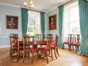 a dining room with a wooden table and chairs at Glamis House in Forfar