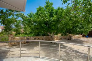 una barandilla de metal delante de un árbol en Arismari House, en Ravdhoúkha