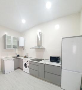 a white kitchen with a sink and a refrigerator at Apartamento Plaza Calzada 3 in Sanlúcar de Barrameda