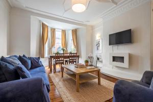 a living room with a blue couch and a table at Spacious Apartment in Jesmond with Parking in Jesmond