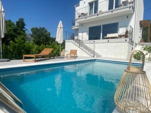 a swimming pool in front of a house at Meridiem Holiday Home in Dubrovnik region in Gruda