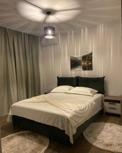 Un dormitorio con una cama grande y una lámpara de araña. en Casa Gazi en Ulcinj