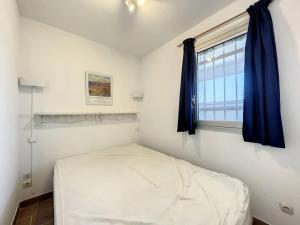 Un dormitorio pequeño con una cama y una ventana. en Appartement T2 cabine vue mer, en Canet-en-Roussillon