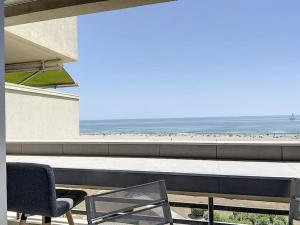 un patio con una mesa y una silla y la playa en Appartement T2 cabine vue mer, en Canet-en-Roussillon