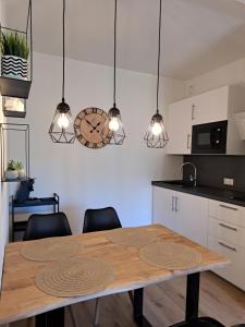 a kitchen with a wooden table and some lights at Harz-Glück-Fewo in Bad Harzburg
