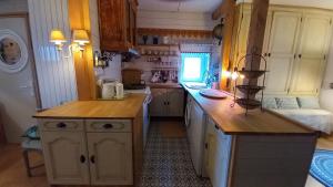 a kitchen with wooden cabinets and a counter top at La Libellule, piscine, climatisation, wifi, vue ,jardin ,parking in Le Vigan