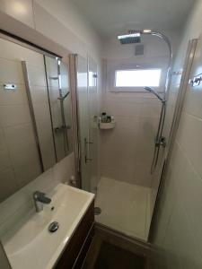 une salle de bain avec une douche et un lavabo et une douche dans l'établissement Bord de plage - Studio en front de mer, au Lavandou