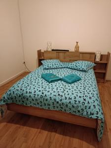 Una cama con dos almohadas verdes encima. en Gîte Holidays mon repos, en Saint-André