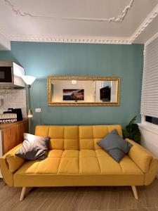 a yellow couch in a living room with a mirror at Aquarium Exclusive Loft - Free Parking in Genoa