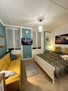 a bedroom with a bed and a couch and a clock at Aquarium Exclusive Loft - Free Parking in Genova