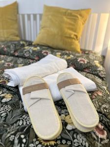 a pair of slippers sitting on top of a bed at Aquarium Exclusive Loft - Free Parking in Genoa