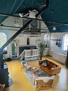 a large living room with a couch and chairs at Kerkje De Kleine Antonius in Zeerijp
