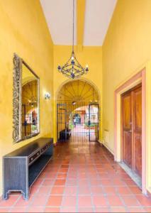 a hallway with a yellow wall and a mirror at L1-cm Loft Apartment In Getsemani With Air Conditioning Pool And WIFI in Cartagena de Indias
