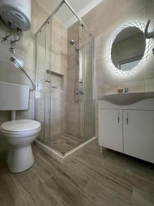 a bathroom with a shower and a toilet and a sink at Casa Gazi in Ulcinj
