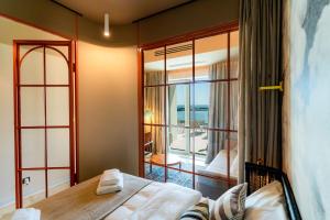 um quarto com uma cama e vista para uma varanda em Rezident Tomis Marina em Constança