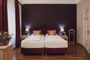 メラーノにあるHotel Adriaのベッドルーム1室(ベッド2台、テーブル2台、ランプ2つ付)
