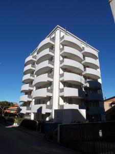 Il propose un grand appartement blanc en face d'un ciel bleu. dans l'établissement Tiepolo Apartments, à Lido di Jesolo