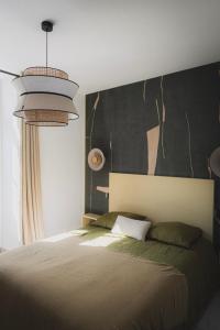 a bedroom with a bed and a black wall at Logis de l'Héronière in Salles-sur-Mer +54 photos