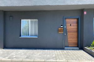 a blue wall with a door and a window at Simlarda Country Club Ayvalık in Ayvalık