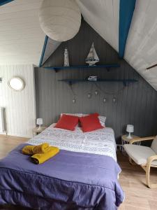 ein Schlafzimmer mit einem großen Bett mit zwei roten Kissen in der Unterkunft Chambre chez l'habitant " Les Ritières " in Plomeur