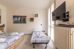 萊科的住宿－[Lago di Como] Lecco Centro - 1’ da lago/stazione，卧室配有一张床,墙上配有电视。