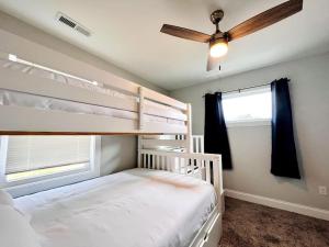 a bedroom with a bunk bed and a ceiling fan at Riverside House in Asheville