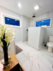 a bathroom with a toilet and a vase of flowers at Riverside House in Asheville +18 photos