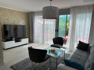 a living room with a couch and a tv at Villa La Miga in Dobra Voda