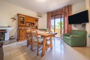 a dining room with a wooden table and a television at Casa Vacanze San Giovanni in San Giovanni Suergiu