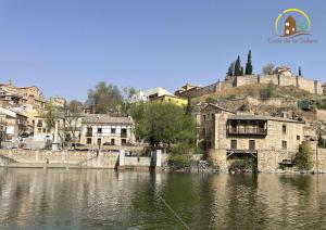 un antiguo edificio a orillas de un río en Casa de la Galera Alojamiento Turístico en Toledo, en Toledo