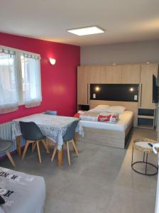 een slaapkamer met 2 bedden en een tafel en stoelen bij Le Conty in Saint-Jorioz