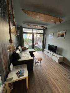 a living room with a couch and a table at Surf Station Tenerife Holiday Apartment Las Americas in Playa de las Americas