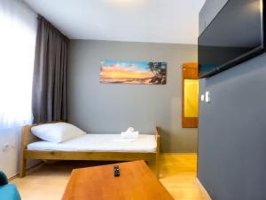 a small room with a bed and a table at GRAND - Beachfront Rooms & Apartments in Selce