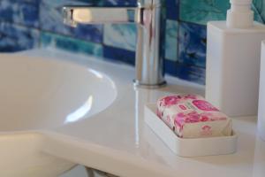 un bancone del bagno con dispenser di sapone e lavandino di Case vacanze la Quercia a Marina di Camerota